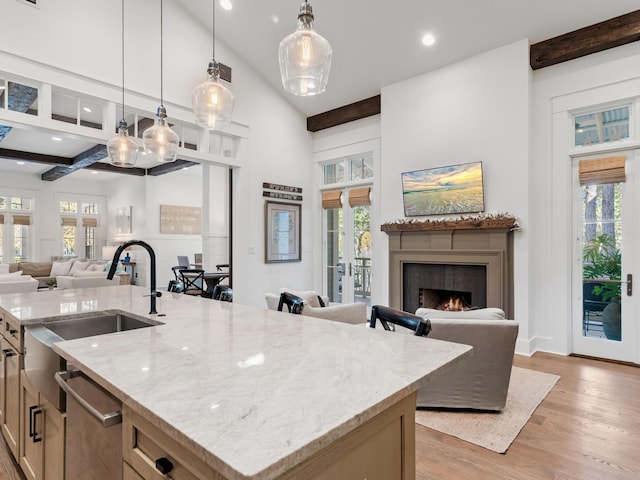 kitchen with pendant lighting, plenty of natural light, and a kitchen island with sink