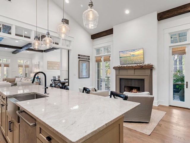 11 Acorn Way, Santa Rosa Beach, FL 32459 - kitchen featuring open floor plan, light wood-type flooring, light stone countertops, an island with sink, and beamed ceiling