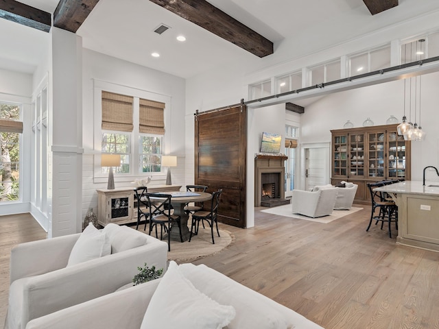 11 Acorn Way, Santa Rosa Beach, FL 32459 - living area featuring light wood finished floors, beam ceiling, plenty of natural light, recessed lighting, and a barn door