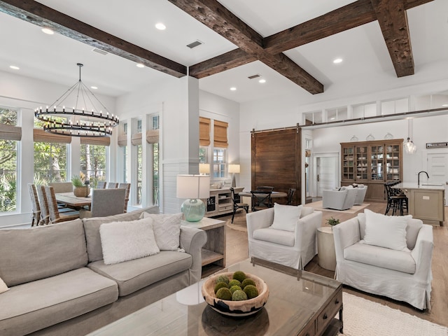 11 Acorn Way, Santa Rosa Beach, FL 32459 - living room with wood finished floors, a chandelier, beam ceiling, recessed lighting, and a barn door
