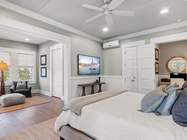 bedroom featuring hardwood / wood-style floors, ceiling fan, ornamental molding, and a wall mounted AC