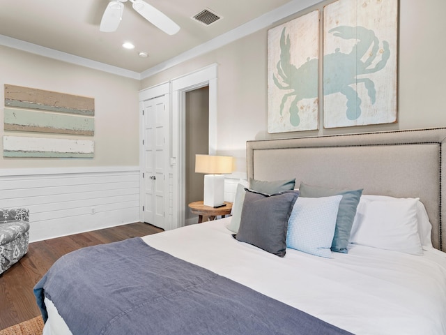 bedroom with a closet, crown molding, ceiling fan, and dark wood-type flooring