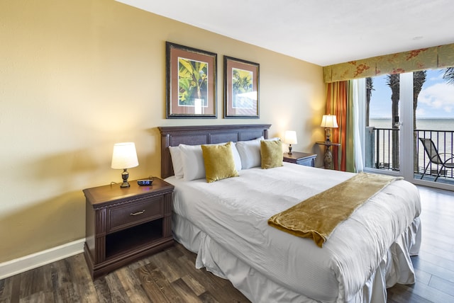 bedroom with access to exterior, dark hardwood / wood-style flooring, and a water view