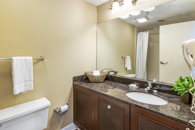 bathroom with a shower with shower curtain, a textured ceiling, vanity, and toilet