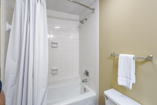 bathroom with toilet, a textured ceiling, and shower / tub combo with curtain