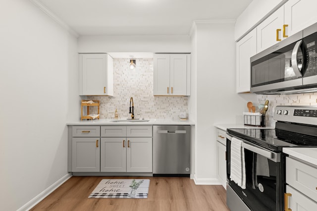 kitchen with white cabinets, appliances with stainless steel finishes, tasteful backsplash, and sink