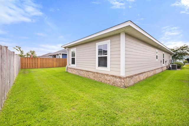 view of home's exterior with a lawn and central air condition unit