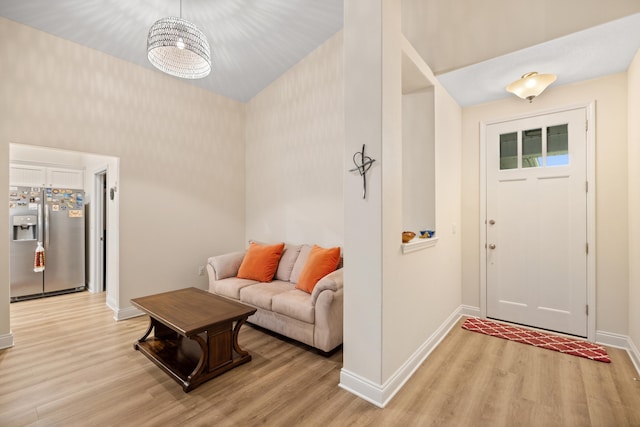 foyer entrance featuring light hardwood / wood-style floors and a notable chandelier