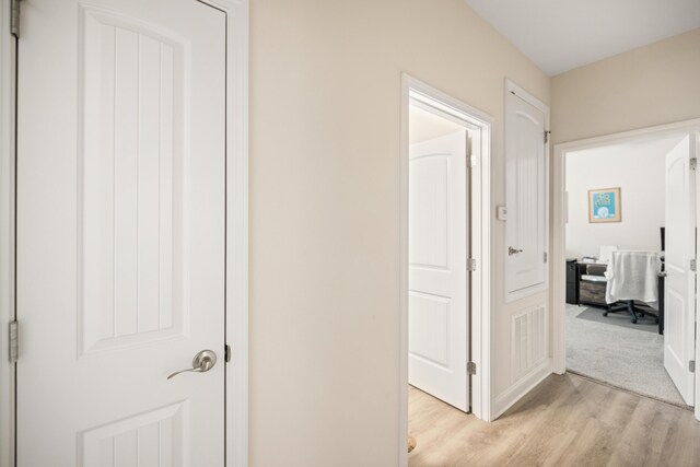 727 Marquis Way, Freeport, FL 32439 - hallway with light wood-type flooring, a desk, and baseboards