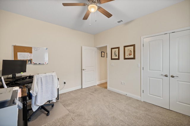 carpeted office space featuring ceiling fan