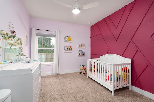 bedroom featuring a crib, carpet flooring, and ceiling fan