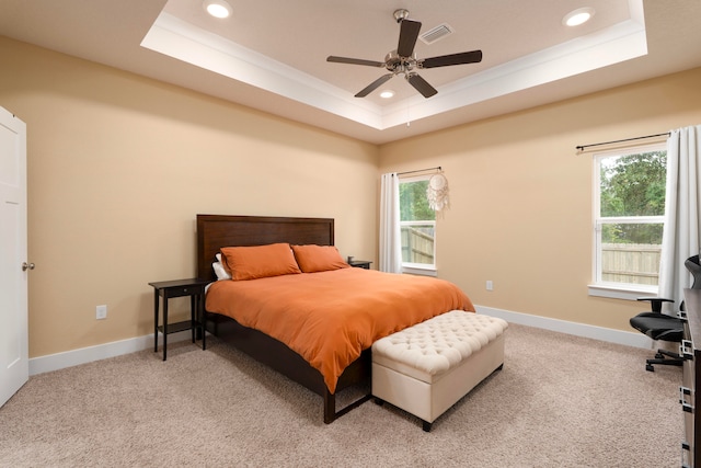 carpeted bedroom featuring crown molding, ceiling fan, and a tray ceiling