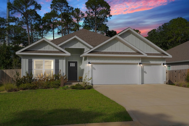 view of front of property with a garage and a yard