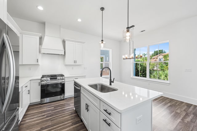 kitchen with white cabinetry, sink, dark wood-type flooring, stainless steel appliances, and a kitchen island with sink