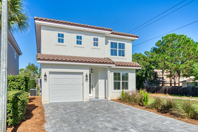 mediterranean / spanish-style house featuring cooling unit and a garage