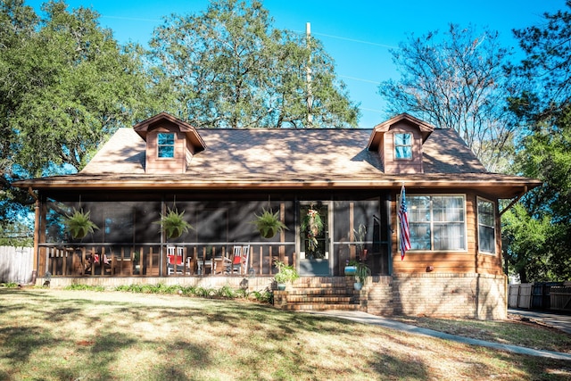 view of front of property with a sunroom and a front lawn