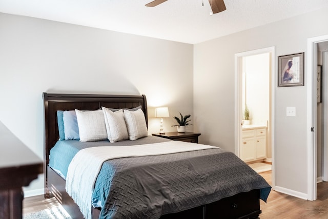 bedroom with light wood-type flooring, ensuite bathroom, and ceiling fan