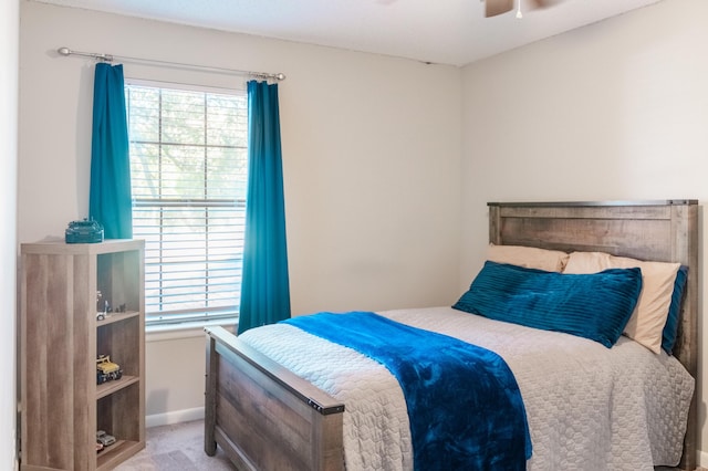 carpeted bedroom with ceiling fan and multiple windows