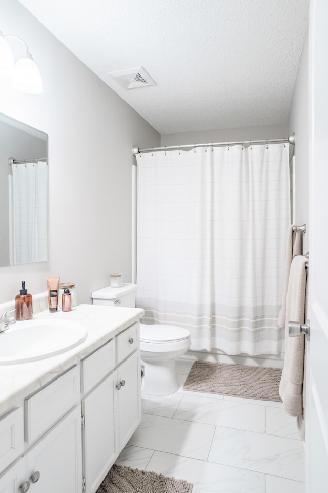 bathroom with vanity, a textured ceiling, and toilet