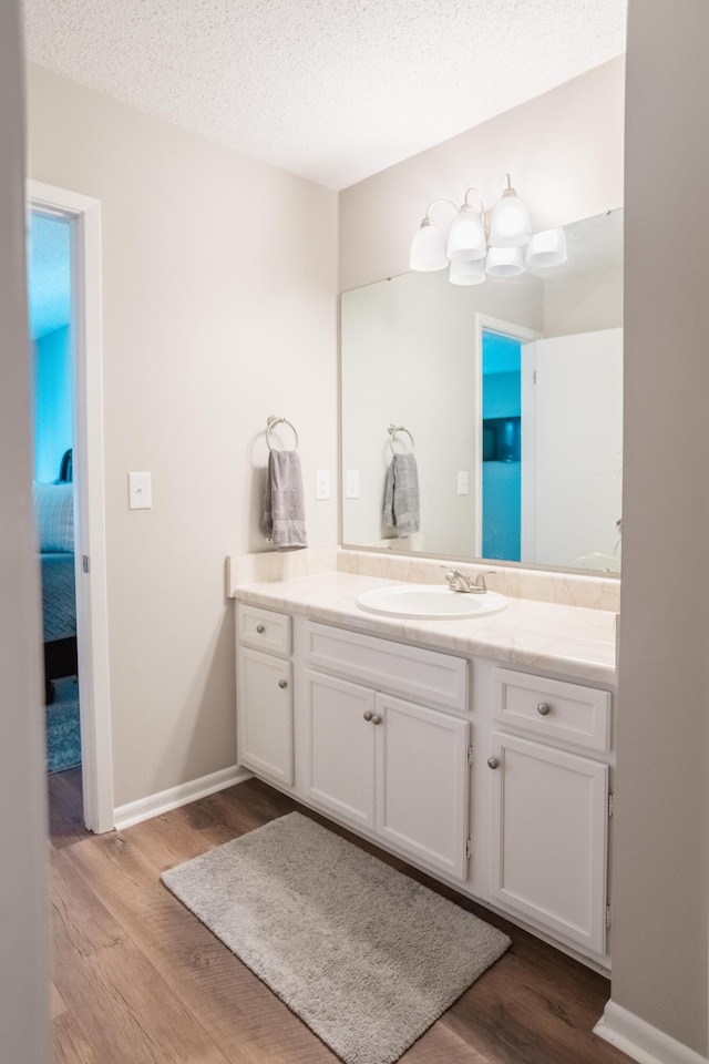 bathroom featuring hardwood / wood-style flooring, vanity, and a textured ceiling