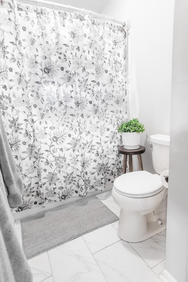 bathroom featuring a shower with curtain and toilet