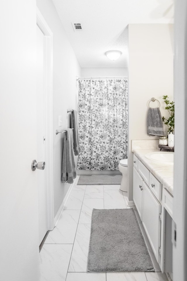 bathroom with curtained shower, vanity, and toilet