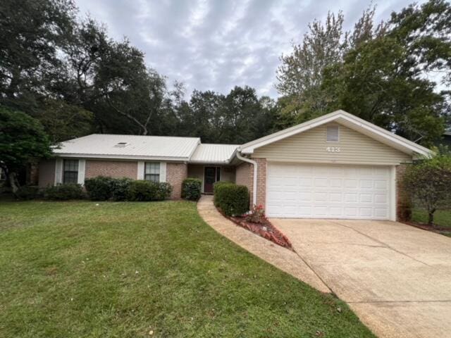 single story home with a garage and a front lawn