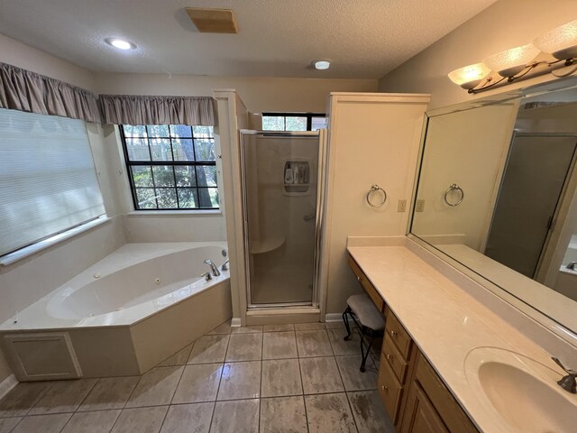 bathroom with a stall shower, vanity, a textured ceiling, a jetted tub, and tile patterned floors