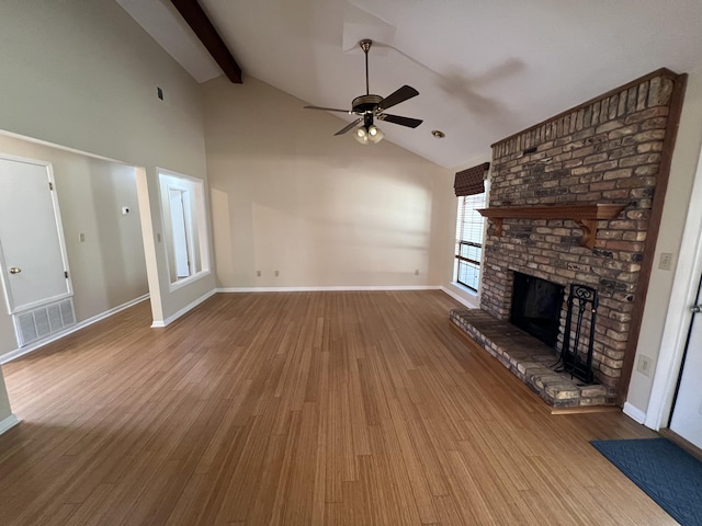 unfurnished living room featuring visible vents, baseboards, light wood-type flooring, a brick fireplace, and beamed ceiling