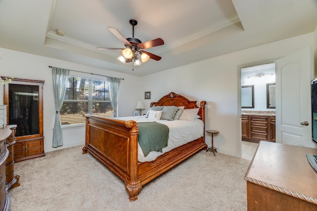 carpeted bedroom featuring crown molding, ensuite bath, a raised ceiling, and ceiling fan