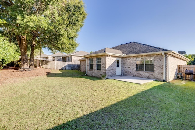 rear view of property with a yard and a patio area