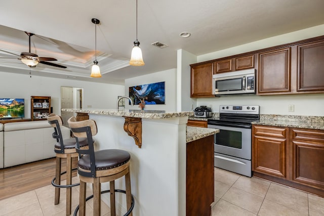 kitchen featuring a center island with sink, stainless steel appliances, and a kitchen bar