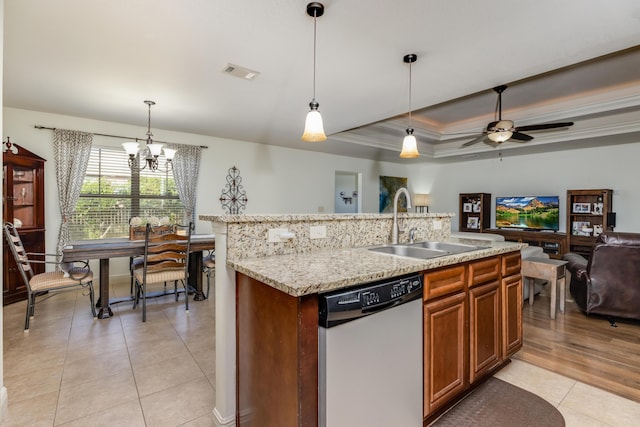 kitchen featuring dishwasher, a tray ceiling, sink, and decorative light fixtures