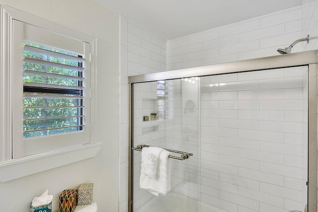 bathroom with an enclosed shower and a wealth of natural light