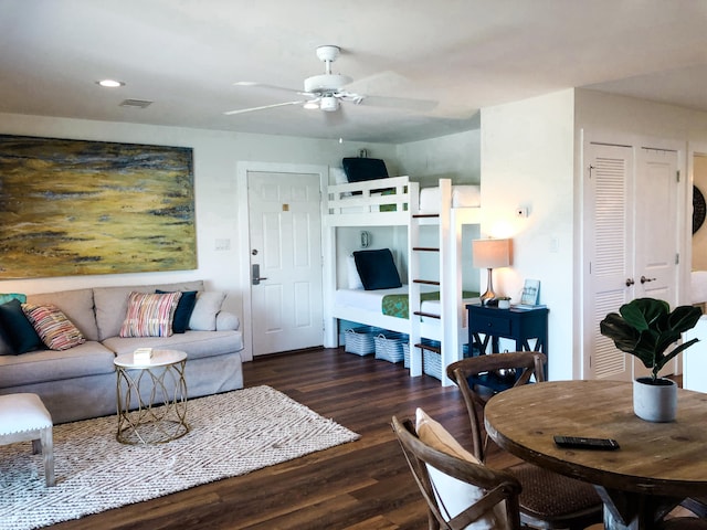 living room with ceiling fan and dark wood-type flooring