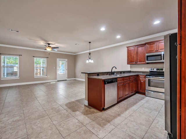 kitchen featuring ceiling fan with notable chandelier, sink, appliances with stainless steel finishes, decorative light fixtures, and kitchen peninsula