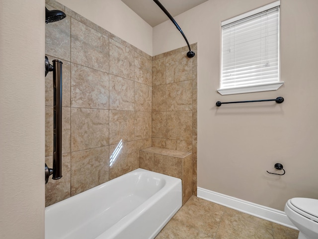 bathroom featuring tile patterned floors, tiled shower / bath, and toilet