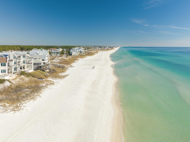 birds eye view of property with a water view and a beach view