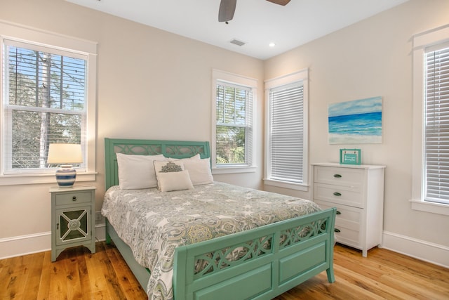 bedroom featuring multiple windows, ceiling fan, and light hardwood / wood-style flooring