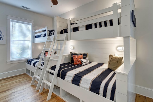 bedroom with ceiling fan, light hardwood / wood-style flooring, and multiple windows