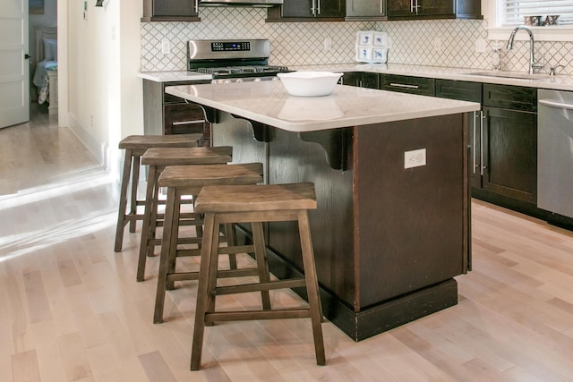 kitchen with light wood-type flooring, a center island, and a breakfast bar area