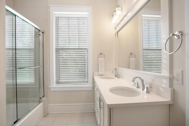 bathroom with tile patterned floors, vanity, combined bath / shower with glass door, and a wealth of natural light