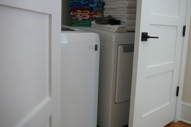 laundry area featuring washing machine and clothes dryer and wood-type flooring