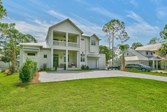 view of front of home with a balcony, a front lawn, ceiling fan, a porch, and a garage