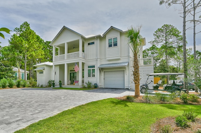 view of front facade featuring ceiling fan, a balcony, a front lawn, and a garage