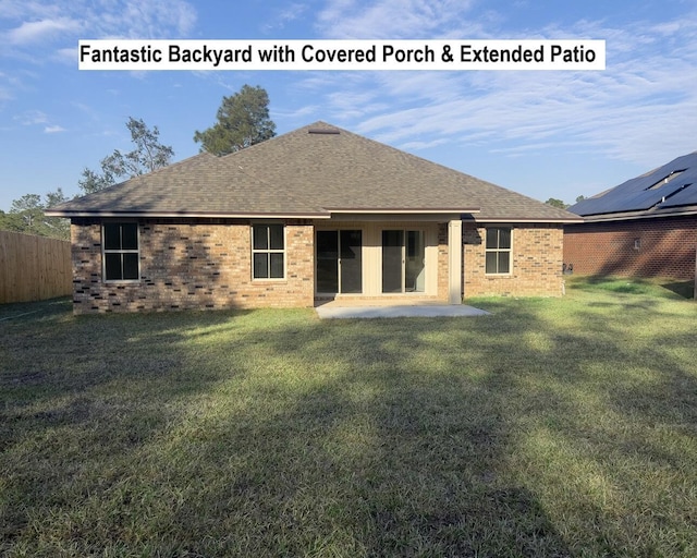 back of house with a shingled roof, fence, a yard, a patio area, and brick siding