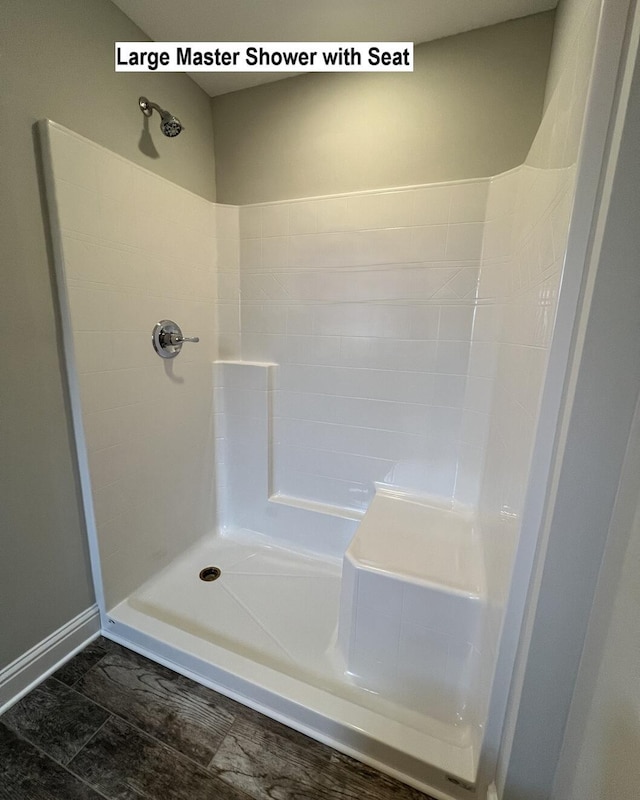 full bathroom with a shower and baseboards