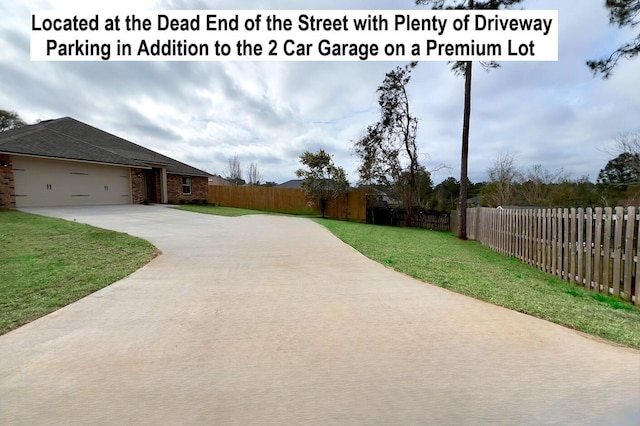 exterior space with a garage, concrete driveway, and fence