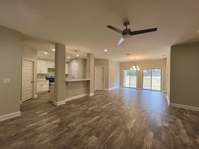 unfurnished living room with dark wood-type flooring and baseboards