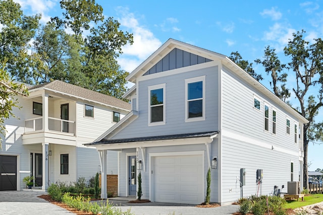 view of front of house featuring a balcony, a garage, and central air condition unit